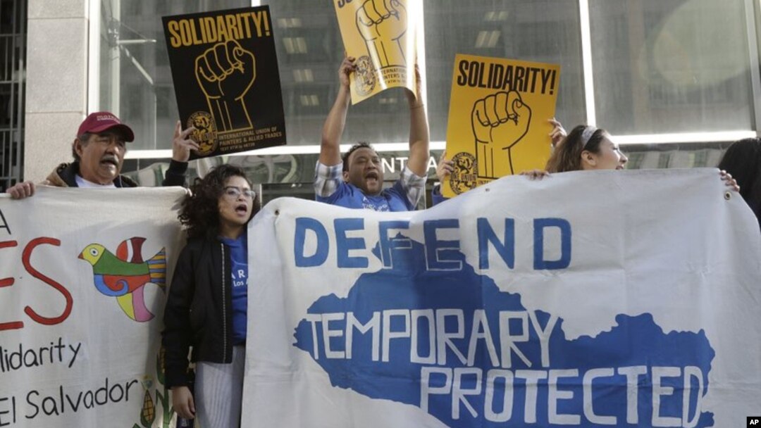 En esta imagen del 12 de marzo de 2018, simpatizantes de los inmigrantes beneficiarios del TPS, sostienen pancartas y gritan consignas durante una marcha previa a una conferencia de prensa en la que se anunció una demanda en contra del gobierno del presidente Donald Trump por su decisión de poner fin a un programa que les permite a los inmigrantes vivir y trabajar legalmente en los Estados Unidos, fuera de una corte federal en San Francisco. (AP Foto/Jeff Chiu, Archivo) 