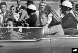 FILE - President John F. Kennedy waves from his car   successful  a motorcade astir   1  infinitesimal  earlier  helium  was shot, Nov. 22, 1963, successful  Dallas.