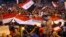 Demonstrators chant in support of Iraqi Prime Minister Haidar al Abadi as they wave national flags during a demonstration at Tahrir Square in Baghdad, Iraq, August 9, 2015.