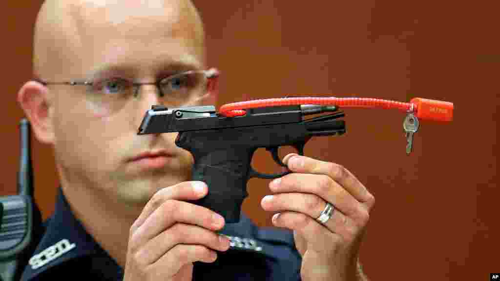 Un policier de Stanford Timothy Smith tient le pistolet qui a été utilisé pour tuer Trayvon Martin, dans le procès George Zimmerman, le 28 juin 2013.