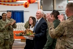 U.S. Vice President Mike Pence and his wife Karen Pence arrive with an early Thanksgiving turkey to serve to U.S. troops at Al Asad Air Base, Iraq, Nov. 23, 2019.