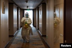 A staff worker disinfects a hotel floor inside the Olympic "closed-loop" during the Beijing 2022 Winter Olympics in Beijing, China, Feb. 8, 2022.