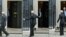 This combination of pictures created shows Lithuania's Prime Minister Ingrida Simonyte (L) reacting after walking past the door to 10 Downing Street, as Britain's Prime Minister Boris Johnson exits late to greet her, in central London, Feb. 8, 2022, ahead