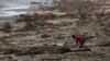 Seorang anak laki-laki mencari barang di antara puing-puing di pantai, setelah Topan Batsirai melanda kota Mananjary, Madagaskar, Selasa 8 Februari 2022. (Foto: Reuters)