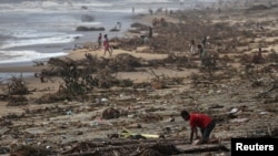 FILE - A boy sifts through debris on the beach, in the aftermath of Cyclone Batsirai, in the town of Mananjary, Madagascar, Feb. 8, 2022.