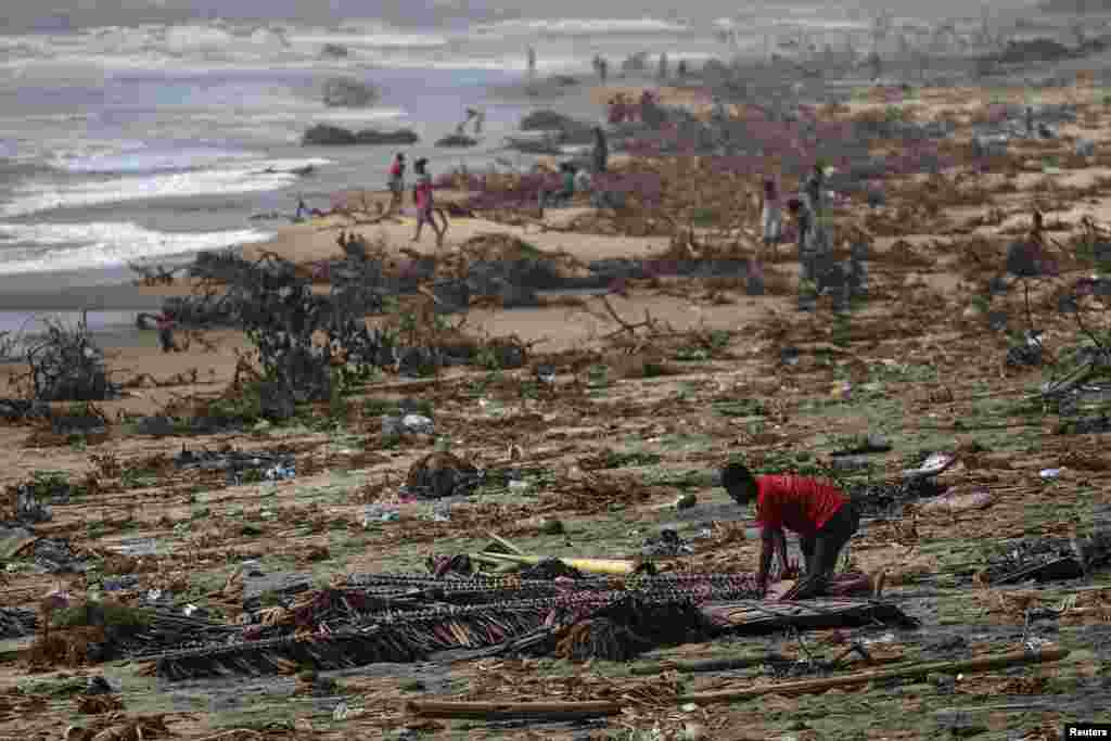 Seorang anak laki-laki mencari barang di antara puing-puing di pantai, setelah Topan Batsirai melanda kota Mananjary, Madagaskar, Selasa 8 Februari 2022. (Foto: Reuters)