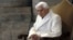 FILE - This Dec. 8, 2015 file photo shows Pope Emeritus Benedict XVI sitting in St. Peter's Basilica as he attends the ceremony marking the start of the Holy Year. 
