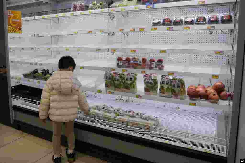 A boy looks at the empty shelves in the vegetable department as residents worry about a shortage of fresh food, at a supermarket in Hong Kong.&nbsp;Hong Kong&#39;s leader announced the city&#39;s toughest social-distancing restrictions yet, including unprecedented limits on private gatherings, as new daily cases surge above 600.