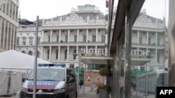 FILE - The Hotel Palais Coburg and a police car are reflected in a window before the meeting of member countries of the Joint Comprehensive Plan of Action (JCPOA) at the Palais Coburg in Vienna, Austria, Feb. 8, 2022.