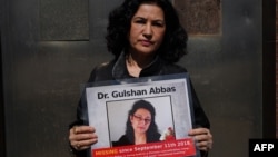 (FILE) Rushan Abbas holds a photo of her sister, Gulshan Abbas who was sentenced to prison by Chinese authorities.