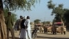 Chadianos observam os veículos militares franceses que circulam num trilho perto de Abeche (Chade Oriental), a 15 de novembro de 2007, enquanto isolam e protegem a parte ocidental da fronteira do Darfur, no Chade. Fotografia de arquivo