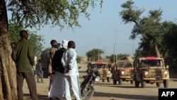 Chadianos observam os veículos militares franceses que circulam num trilho perto de Abeche (Chade Oriental), a 15 de novembro de 2007, enquanto isolam e protegem a parte ocidental da fronteira do Darfur, no Chade. Fotografia de arquivo