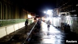 FILE - A police officer and soldiers walk as they deploy during the launch of the new security policy in San Salvador, El Salvador, June 20, 2019. 