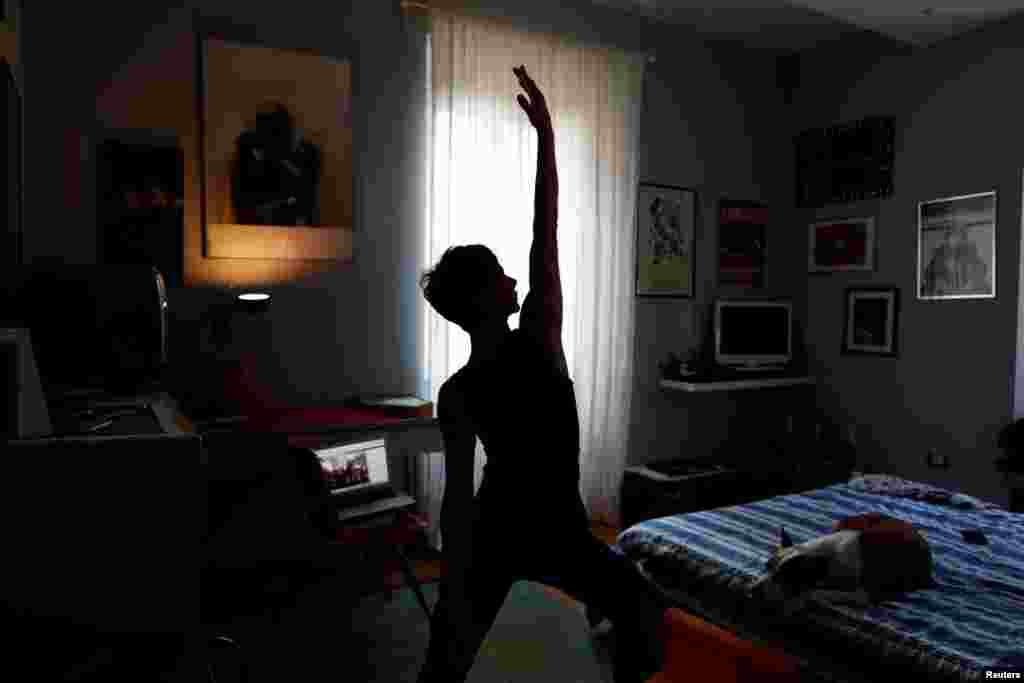 Francesca Valagussa, 40, practices yoga using an online course, in Rome, Italy, March 16, 2020. Italy entered its seventh day of a nationwide coronavirus lockdown after the government restricted movement for citizens.
