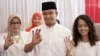 Gubernatorial candidate Anies Baswedan, center, and his family show their ink-dipped fingers after giving their votes during the local election in Jakarta, Indonesia, April 19, 2017.