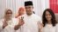 Gubernatorial candidate Anies Baswedan, center, and his family show their ink-dipped fingers after giving their votes during the local election in Jakarta, Indonesia, April 19, 2017.