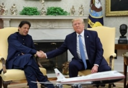 FILE - Pakistan’s Prime Minister Imran Khan shakes hands with U.S. President Donald Trump at the start of their meeting in the Oval Office of the White House in Washington, July 22, 2019.