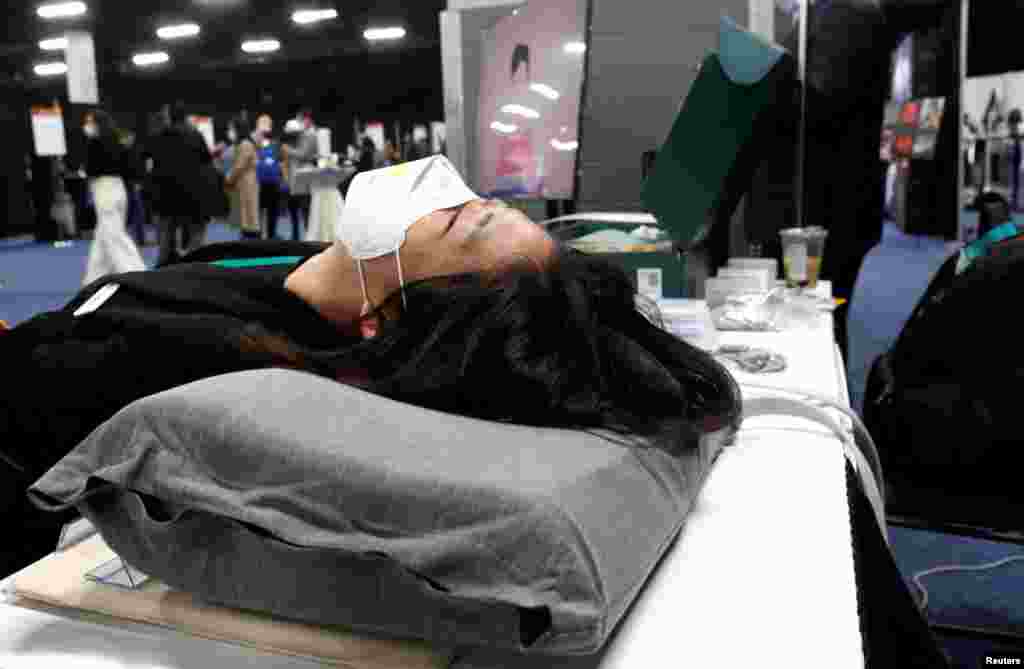 Sophie Lee posa sobre una Motion Pillow contra los ronquidos en el stand de Ten Minds durante CES 2022.