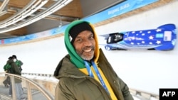 Chris Stokes poses for a photo by the track as the 2-man bobsled training takes place during the Beijing 2022 Winter Olympic Games in Yanqing on Feb. 10, 2022.