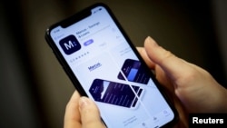 FILE PHOTO- A woman looks at Marcus, a savings and loans app by Goldman Sachs, in New York, U.S., on January 10, 2020. REUTERS/Mike Sega