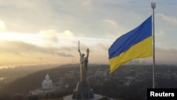 La bandera más grande de Ucrania y el monumento de la "Patria", se ven desde un complejo del museo de la Segunda Guerra Mundial en Kiev. Foto de Reuters del 16 de diciembre de 2021.
