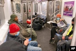 Not everyone chooses to wear a mask while riding the subway in New York City, January 28, 2022.
