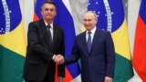 El presidente ruso, Vladimir Putin, y su homólogo brasileño, Jair Bolsonaro, se dan la mano