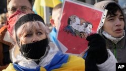 Ukrainians attend a rally in central Kyiv, Ukraine, Saturday, Feb. 12, 2022, during a protest against the potential escalation of the tension between Russia and Ukraine. 