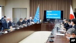 In this photo provided by Japan's Ministry of Economy, Trade and Industry (METI), members of International Atomic Energy Agency taskforce team attend a meeting with Japanese government officials, at the ministry in Tokyo, Feb. 14, 2022.