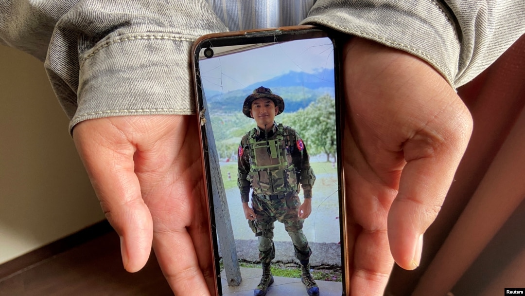 Kaung Thu Win, who said he served as a captain in Myanmar's military before defecting in late December, shows a photograph of himself wearing an army uniform on his mobile phone, during an interview with Reuters at an undisclosed location in northeastern India, Jan. 21, 2022.