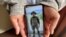 Kaung Thu Win, who said he served as a captain in Myanmar's military before defecting in late December, shows a photograph of himself wearing an army uniform on his mobile phone, during an interview with Reuters at an undisclosed location in northeastern India, Jan. 21, 2022.