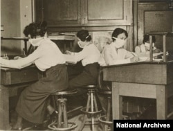 Clerks in New York City wear masks while working in 1918.