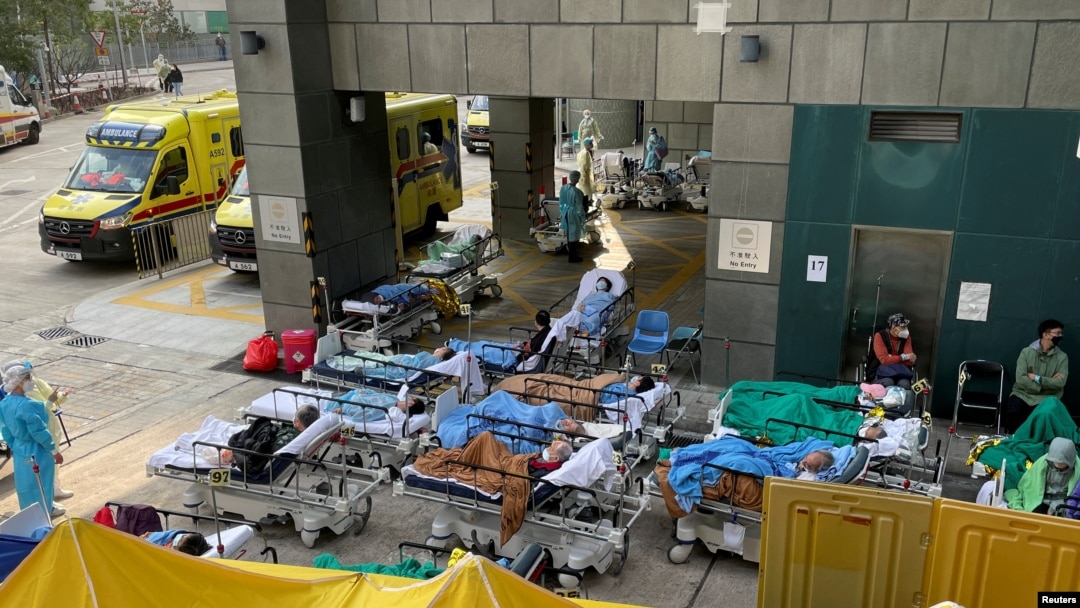 Pasien yang memakai masker berbaring di tempat tidur di area perawatan darurat di luar rumah sakit, menyusul wabah COVID-19 di Hong Kong, China, 16 Februari 2022. (Foto: REUTERS/Aleksander Solum)