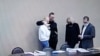 Russian opposition leader Alexei Navalny, his wife Yulia Navalnaya and lawyers Olga Mikhailova and Vadim Kobzev are seen on a screen via a video link during a court hearing at the IK-2 male correctional facility, in the town of Pokrov, Feb. 15, 2022.