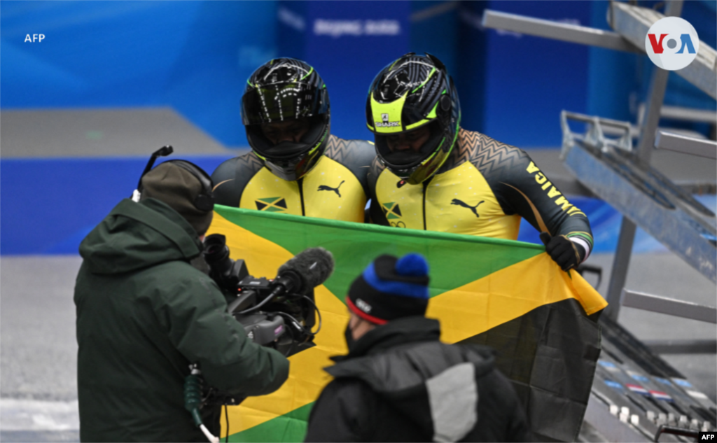 Shanwayne Stephens y Nimroy Turgott, de Jamaica, sostienen la bandera nacional después de competir en el evento de Bobsled por parejas.&nbsp;