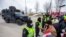 FILE - Protesters interact with police officers who stand guard on a street after Windsor Police said that they are starting to enforce a court order to clear truckers and supporters blocking access to the Ambassador Bridge, Feb. 13, 2022.