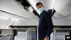 Novak Djokovic prepares to take his seat on a plane to Belgrade, in Dubai, United Arab Emirates, Monday, Jan. 17, 2022. (AP Photo/Darko Bandic, FILE)