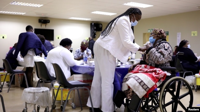 FILE - A woman gets a COVID-19 vaccine as South Africa rolls out coronavirus disease vaccinations to the elderly at the Munsieville Care for the Aged Centre outside Johannesburg, South Africa, May 17, 2021.