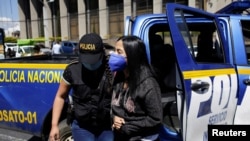 La abogada Leily Santizo, exdirectora de la comisión anticorrupción CICIG, es escoltada por un oficial de policía mientras llega al edificio de la Corte Suprema de Justicia en la Ciudad de Guatemala, el 10 de febrero de 2022.