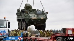 美国陆军发布的照片显示，美国陆军第二骑兵团第二营的军人在德国菲尔埃斯科的军事基地将一辆史崔克装甲车装上卡车。这支部队将调往罗马尼亚。(2022年2月9日)
