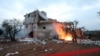 FILE - Red tape is extended and objects are set on fire around the house in which the leader of the Islamic State group, Abu Ibrahim al-Hashimi al-Qurashi, died during a raid by U.S. special forces in northwestern Syria in February.