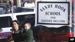 FILE — Mzazi akiondoka na mtoto wake kutoka Shule ya Msingi ya Sandy Hook baada ya shambulizi la bunduki shuleni mjini Newtown, Connecticut, Disemba 14, 2022. (Frank Becerra Jr./The Journal News via AP)