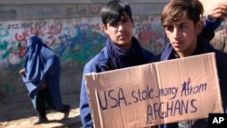 Afghan protesters hold placards and shout slogans against US during a protest condemning President Joe Biden's decision, in Kabul, Afghanistan, Feb. 12, 2022. 