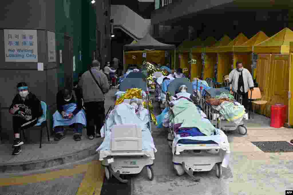 People lie in hospital beds outside Caritas Medical Centre in Hong Kong as the city faces its worst Covid-19 coronavirus wave to date.