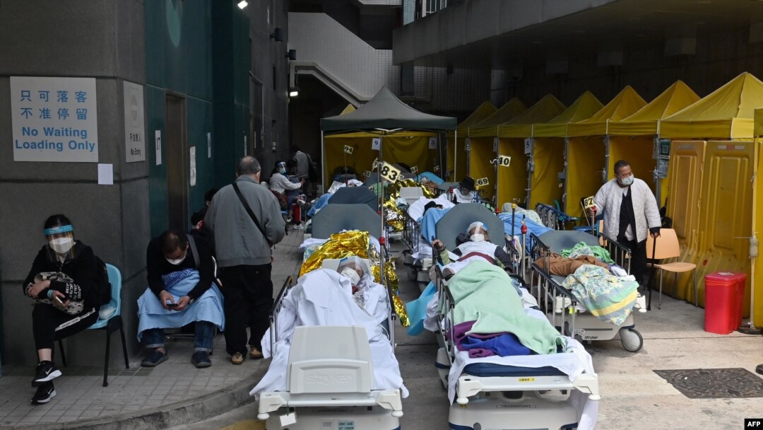 Para pasien berbaring di ranjang di luar sebuah rumah sakit, karena penuhnya kamar-kamar rumah sakit di Hong Kong Selasa (15/2), sementara kota itu menghadapi lonjakan pandemi COVID-19 terburuk saat ini. (Foto: AFP)