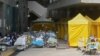 Pasien mengenakan masker, berbaring di tempat tidur di area luar rumah sakit, di tengah pandemi COVID-19 di Hong Kong, 15 Februari 2022. (REUTERS/Lam Yik)