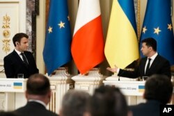 Ukrainian President Volodymyr Zelenskyy, right, gestures towards French President Emmanuel Macron during a joint press conference, Feb. 8, 2022 in Kyiv, Ukraine.