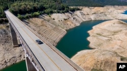 In this file photo, a car crosses Enterprise Bridge over Lake Oroville's dry banks on May 23, 2021, in Oroville, Calif. (AP Photo/Noah Berger, File)