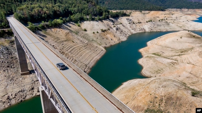 In this file photo, a car crosses Enterprise Bridge over Lake Oroville's dry banks on May 23, 2021, in Oroville, Calif. (AP Photo/Noah Berger, File)