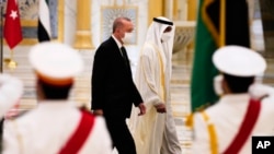 Turkish President Recep Tayyip Erdogan, left, and Abu Dhabi Crown Prince Sheikh Mohammed bin Zayed Al Nahyan look over an honor guard at Qasr Al-Watan in Abu Dhabi, United Arab Emirates, Feb. 14, 2022. 